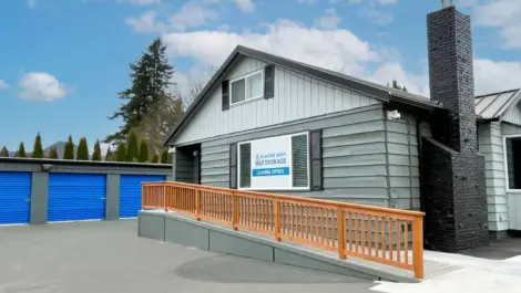 Storage facility with a leasing office and blue storage units.