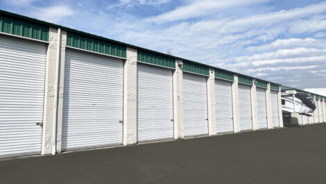 Exterior view of the Glacier West Self Storage facility in Edgewood, Washington, featuring beige buildings with green accents and drive-up storage units.